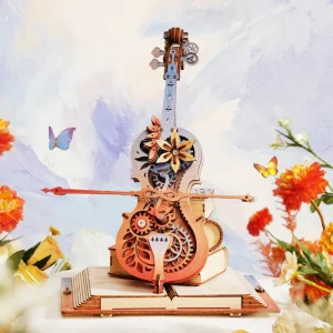 ROKR Symphony of Gorgeous Dreams AMK63M, boîte à musique mécanique en bois représentant un violoncelle coloré posé sur des livres avec engrenages apparents et archet mobile.