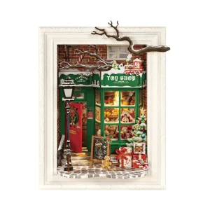 Diorama 3D en bois Rolife DP006 représentant une boutique de jouets de Noël avec façade verte, porte rouge, sapin enneigé, cadeaux et décorations festives.