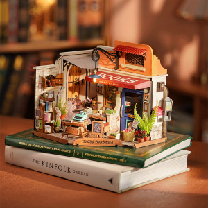 Maison miniature DIY Rolife Corner Bookstore DG164 représentant une librairie d’angle rétro avec livres, étagères, plantes, accessoires et éclairage LED chaleureux.