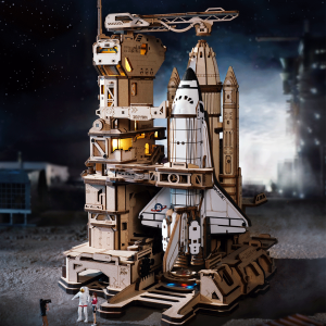 Puzzle 3D mécanique en bois ROKR Space Shuttle LKA02 représentant une navette spatiale sur une base de lancement futuriste avec tour de contrôle, bras mécaniques.