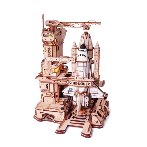 Puzzle 3D mécanique en bois ROKR Space Shuttle LKA02 représentant une navette spatiale sur une base de lancement futuriste avec tour de contrôle, bras mécaniques.