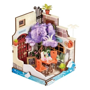 Rolife Sea Holiday Restaurant DS039, maison miniature 3D représentant un restaurant en bord de mer avec arbre fleuri violet, table extérieure orange, plantes, mouettes et vagues bleues.