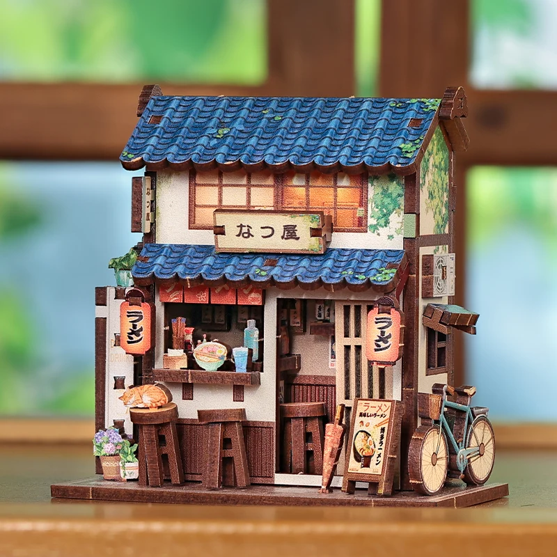 Magnet miniature Ramen Shop en bois représentant un restaurant japonais traditionnel avec toit bleu, lanternes rouges et petits accessoires détaillés.